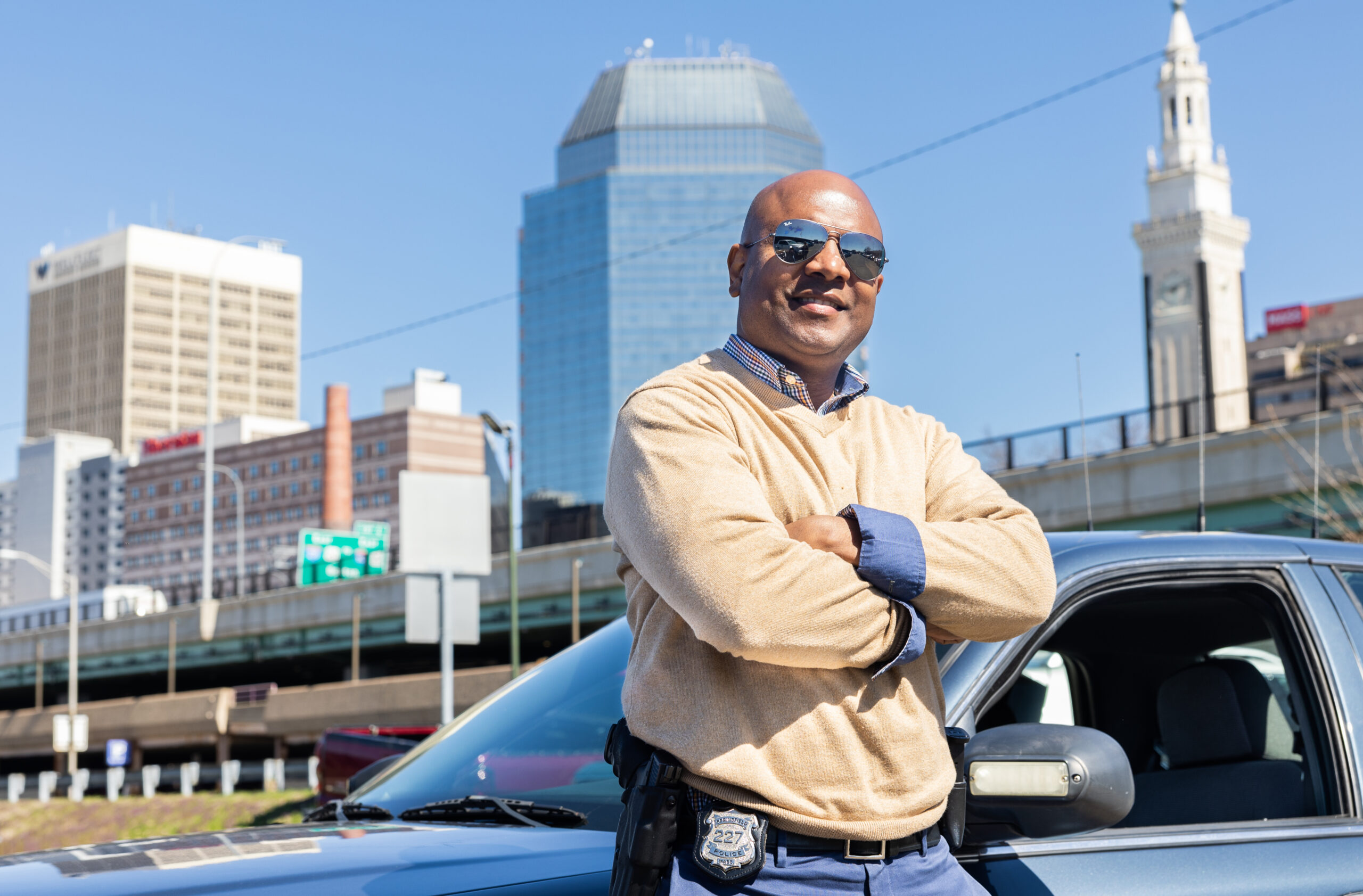 Orette leans on his police cruiser in front of the Springfield skyline.