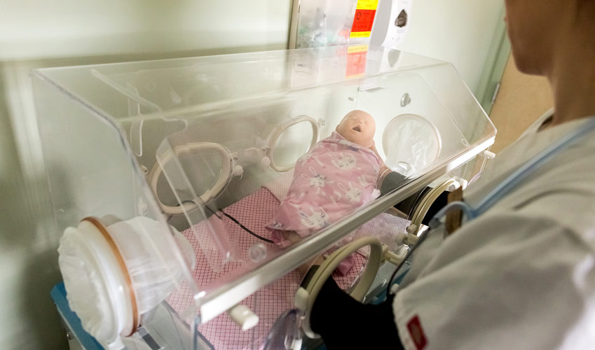 Nurse Caring for Baby Doll in Incubator